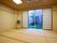 畳敷きの和室の部屋にはテレビが置かれ、窓の外には日本庭園がある。