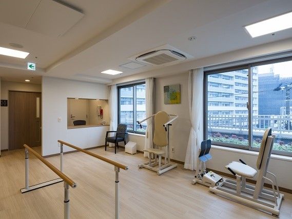 トレーニング機器が並べてある施設内のトレーニングルーム。左側に歩行器が置いてある様子