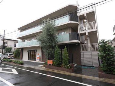 施設の外壁はブラウン色が基調となっており、３階建ての建物である。外階段があり、緊急時の避難経路が確保されている。