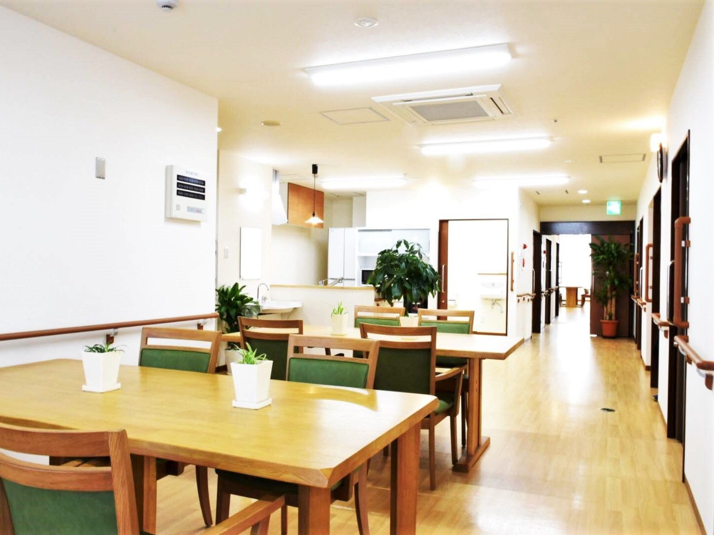 明るいリビングダイニングにはダイニングテーブルが二つ置かれ、右側に居室のドアが設置されている。