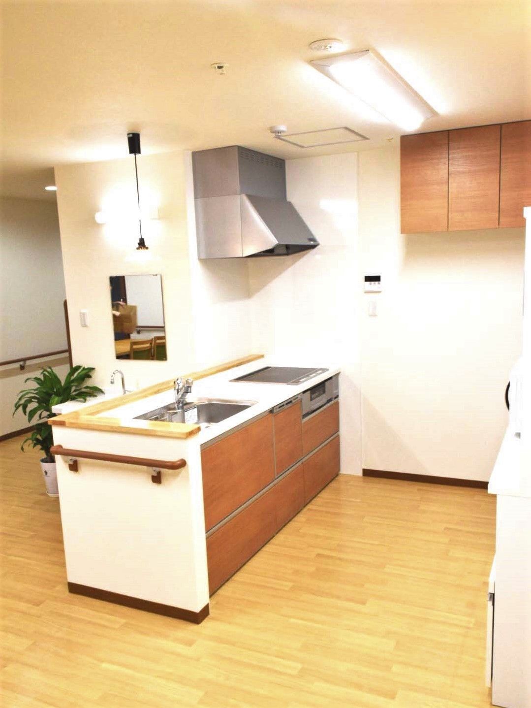オール電化のキッチンはブラウン系で手すりも付いている。キッチンの作業スペースも広い。