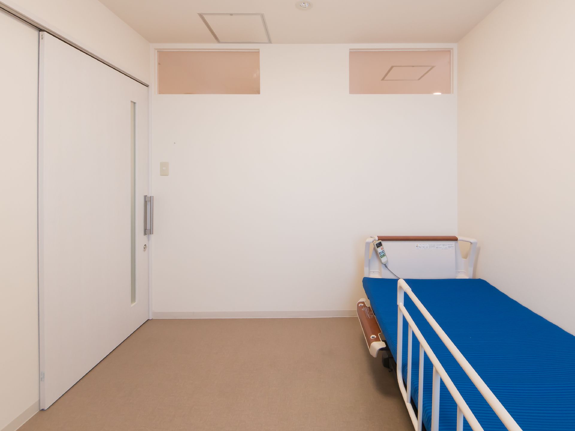 居室の床は段差のないフローリングである。ドアは間口の広い引き戸を採用している。介護用ベッドが設置されている。