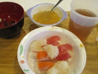 貝やマグロ、鮭などの小さなサイズの握り寿司が並んだ皿が中央にあり、汁物やお茶、ゼリーもある。