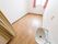 入口のそばにトイレと洗面台があるほかには、何も置いていないシンプルでさっぱりとした室内である。奥の壁には高めの位置に窓がある。