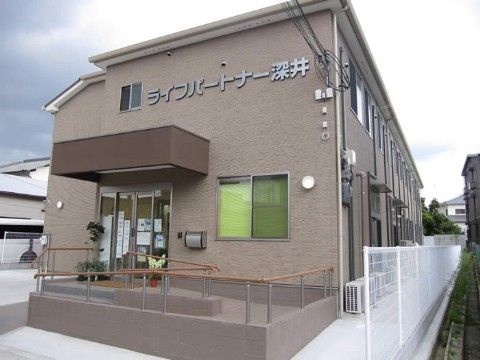 施設玄関上部の外壁に施設名称の文字プレートを設置した２階建て施設