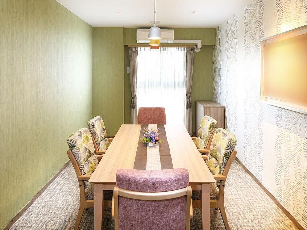 木製のテーブルと柄付きの椅子が並べられた、コンパクトな空間