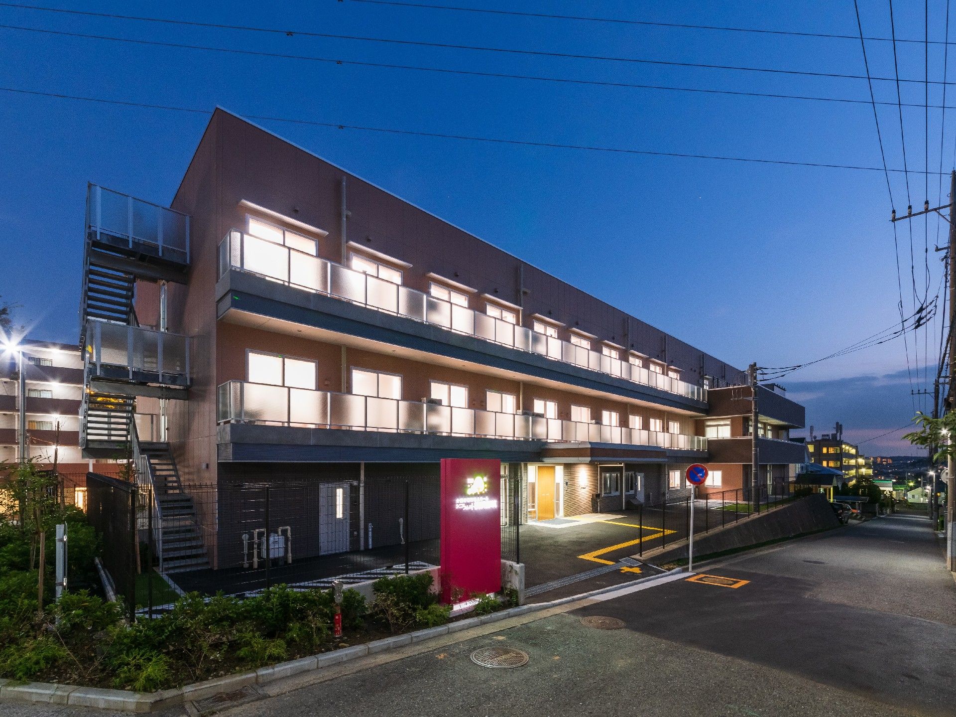 駐車場が付いた大きな３階建ての建物。各フロアにはベランダも付いている。