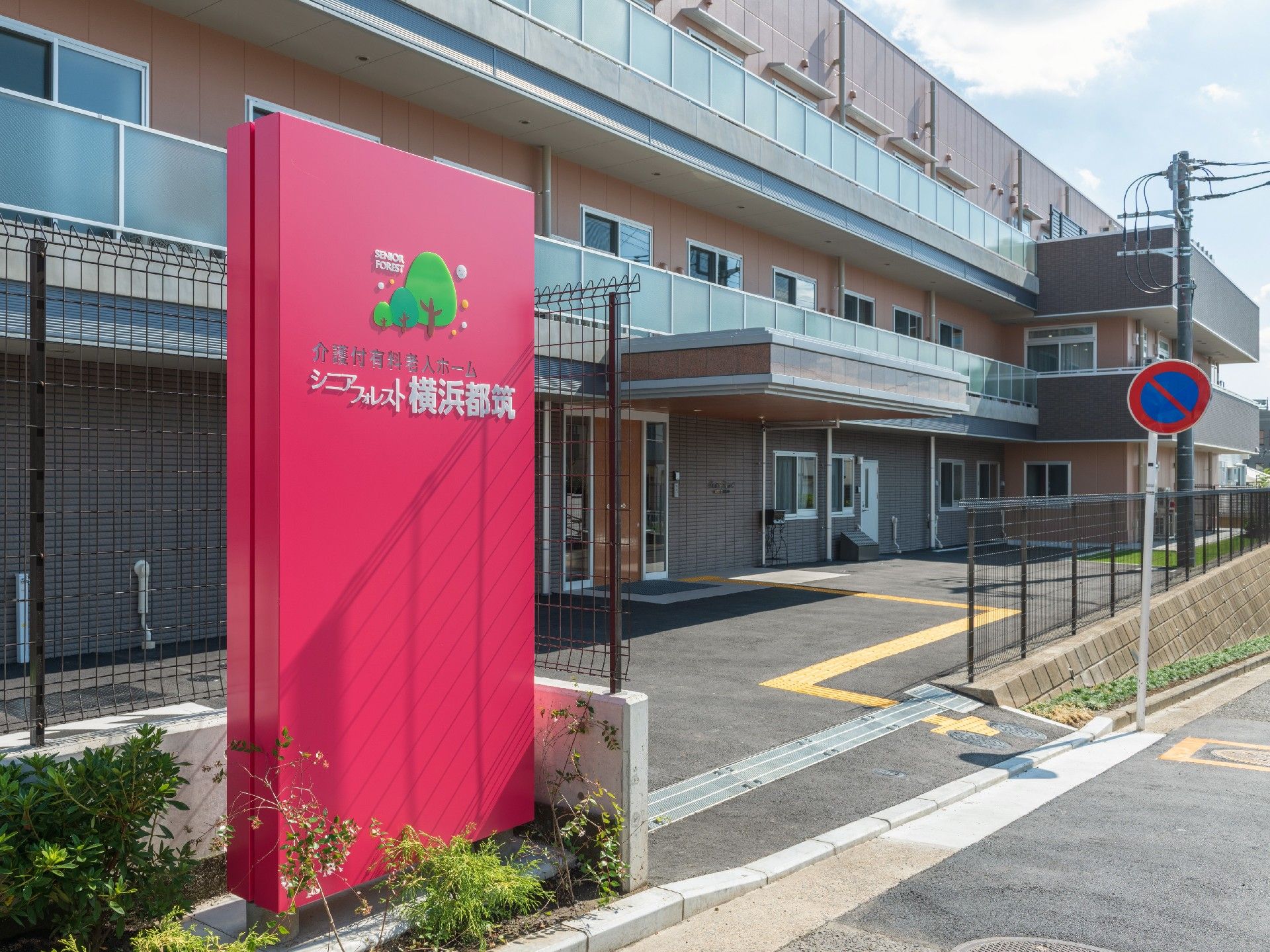 3階建ての建物のエントランスには車寄せがあり、敷地内にはエントランスに続く点字ブロックがある。