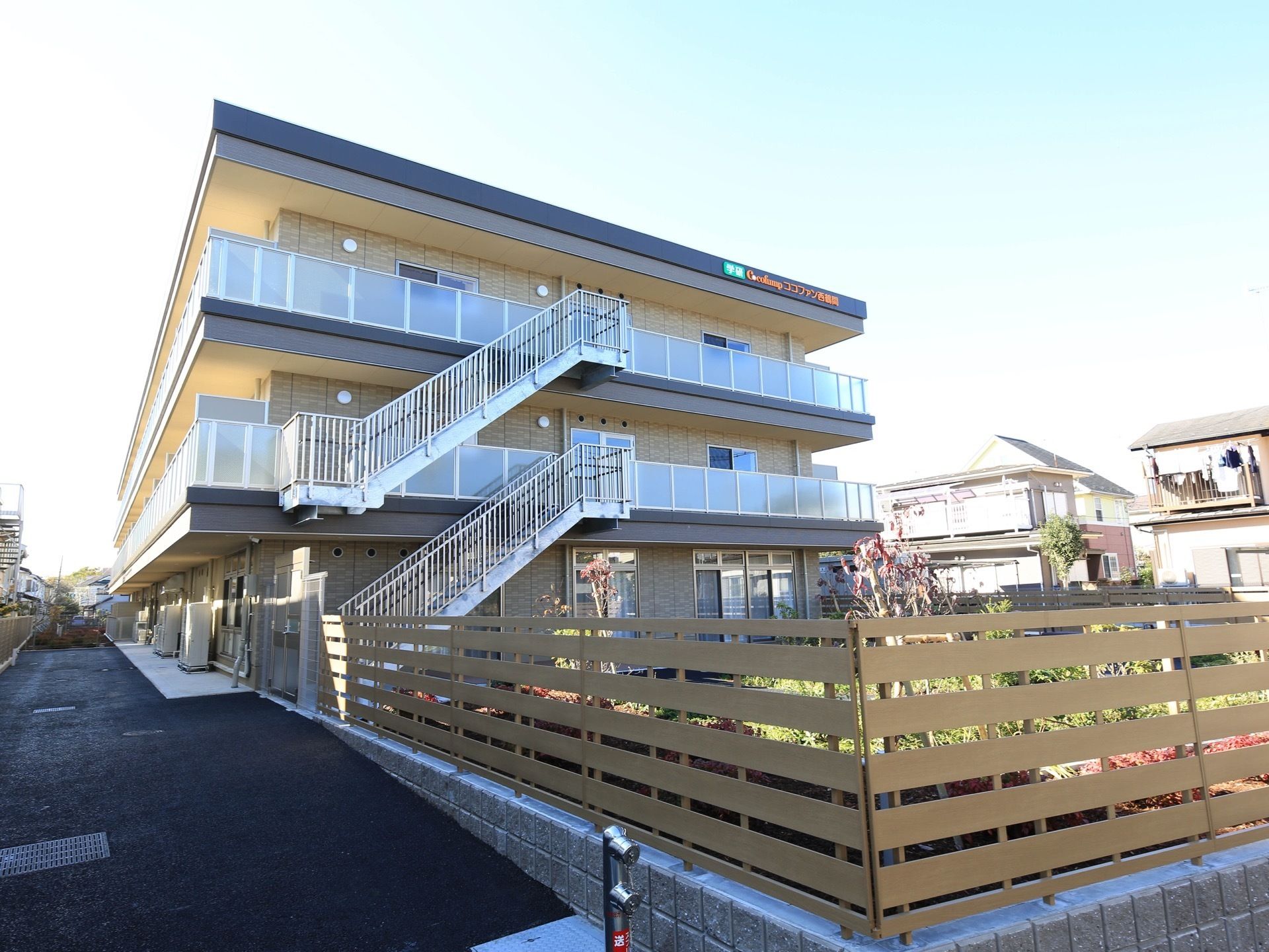 ３階建てで平屋根の建物。各階ごとにテラスやベランダがあり、それぞれ屋根がかかっている。避難階段が設けられている。