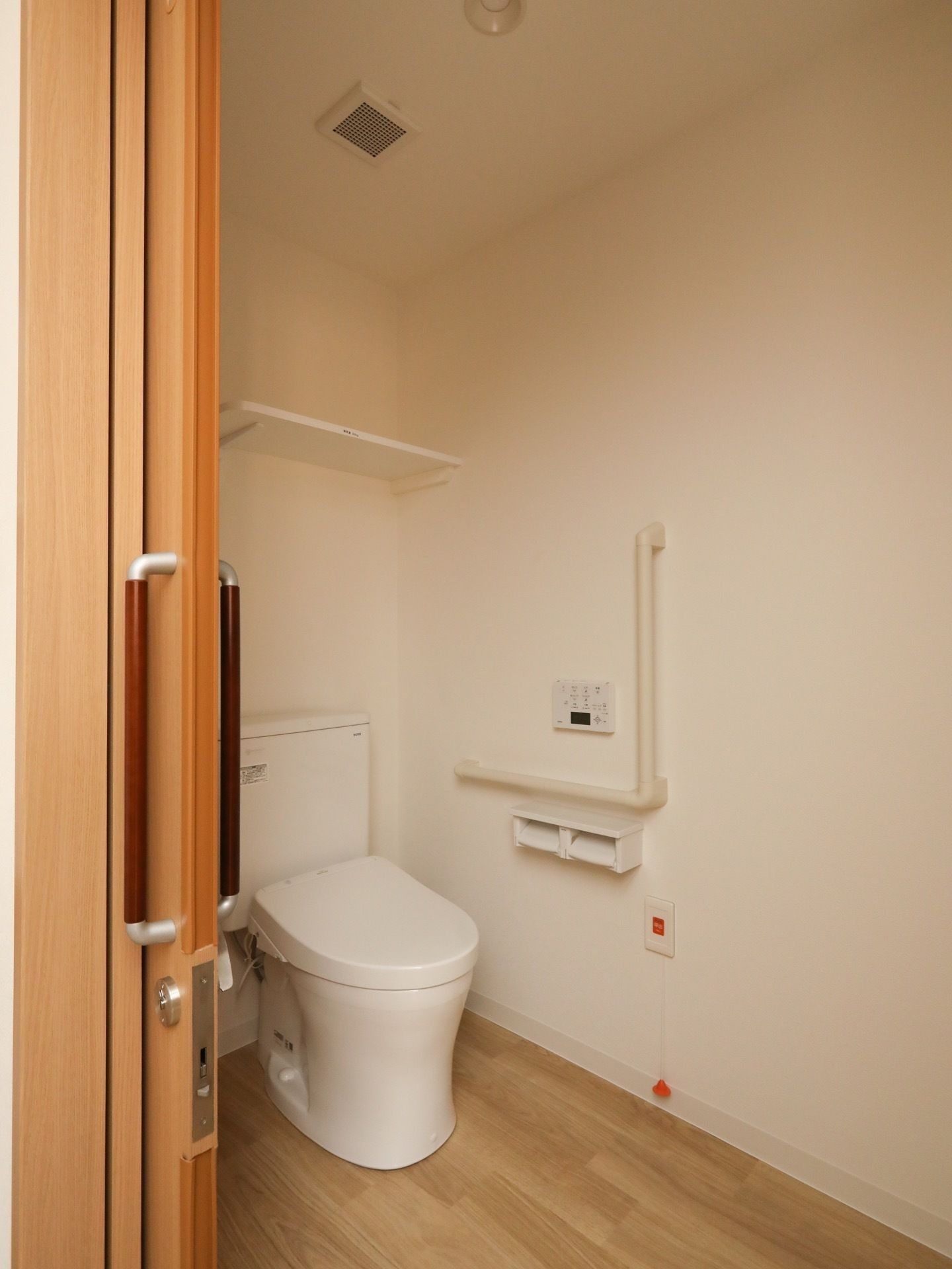 居室のトイレには、温水洗浄便座付きの便器が取り付けてある。壁の操作ボタンを押して、誰でも簡単に利用できる。