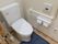 洋式便器と温水洗浄便座、Ｌ字型の手すり、トイレットペーパーホルダー、非常用呼び出しブザーなどがある。