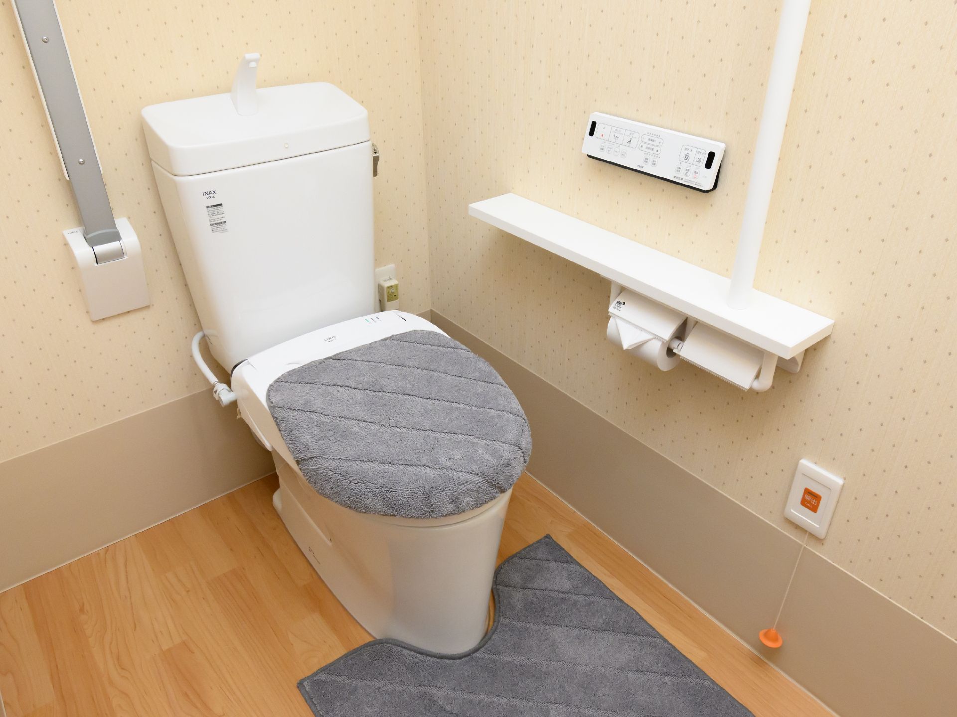 バリアフリー完備で、壁に手すりが設置されているトイレ