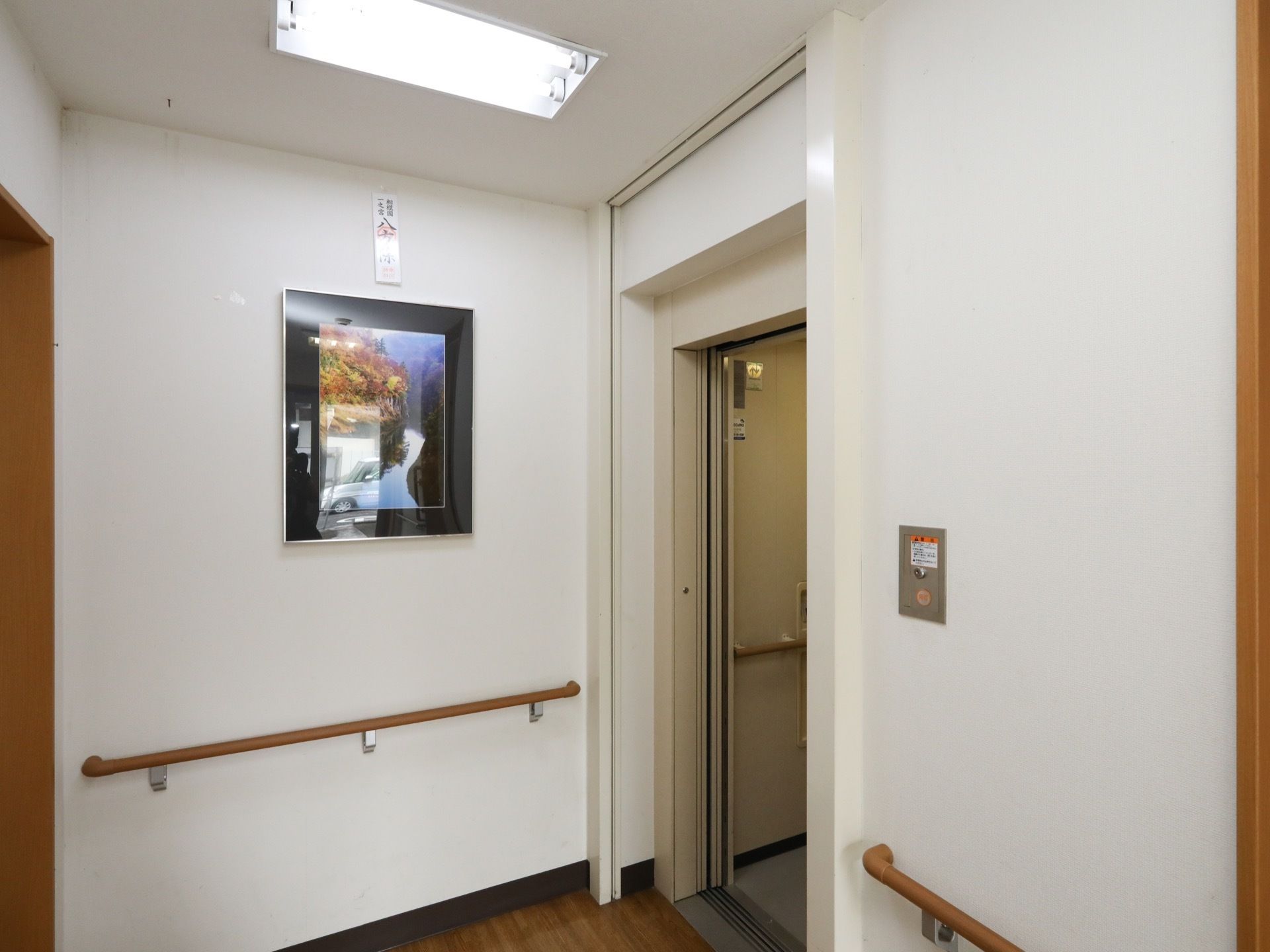 廊下のつきあたりにエレベーターが設置されている。内部の壁には、廊下と同じ高さに手すりが設置されている。