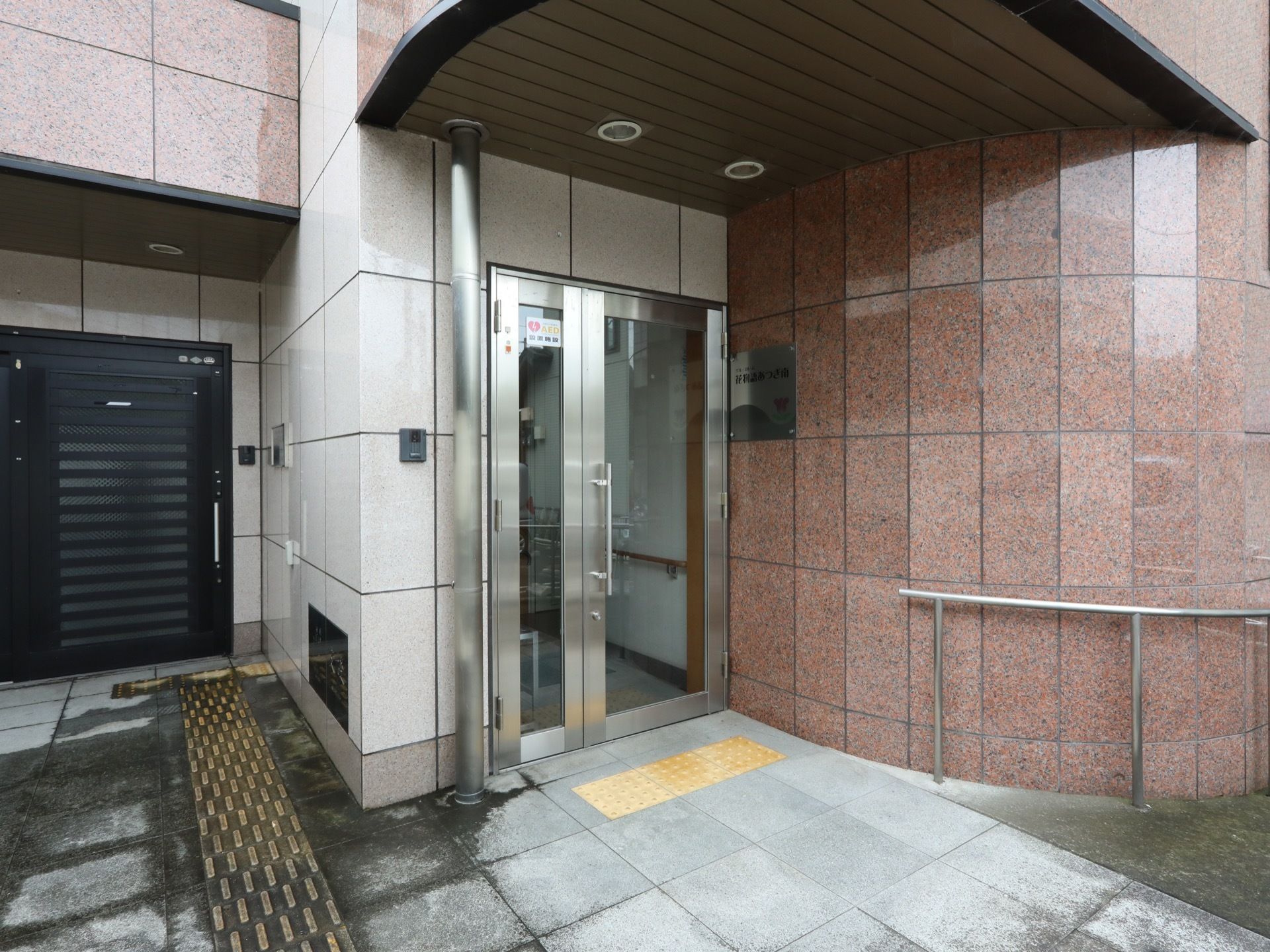 玄関は、取っ手がついた大きなガラスの引き戸である。ひさしがあり、その天井には、ダウンライトが２つついている。