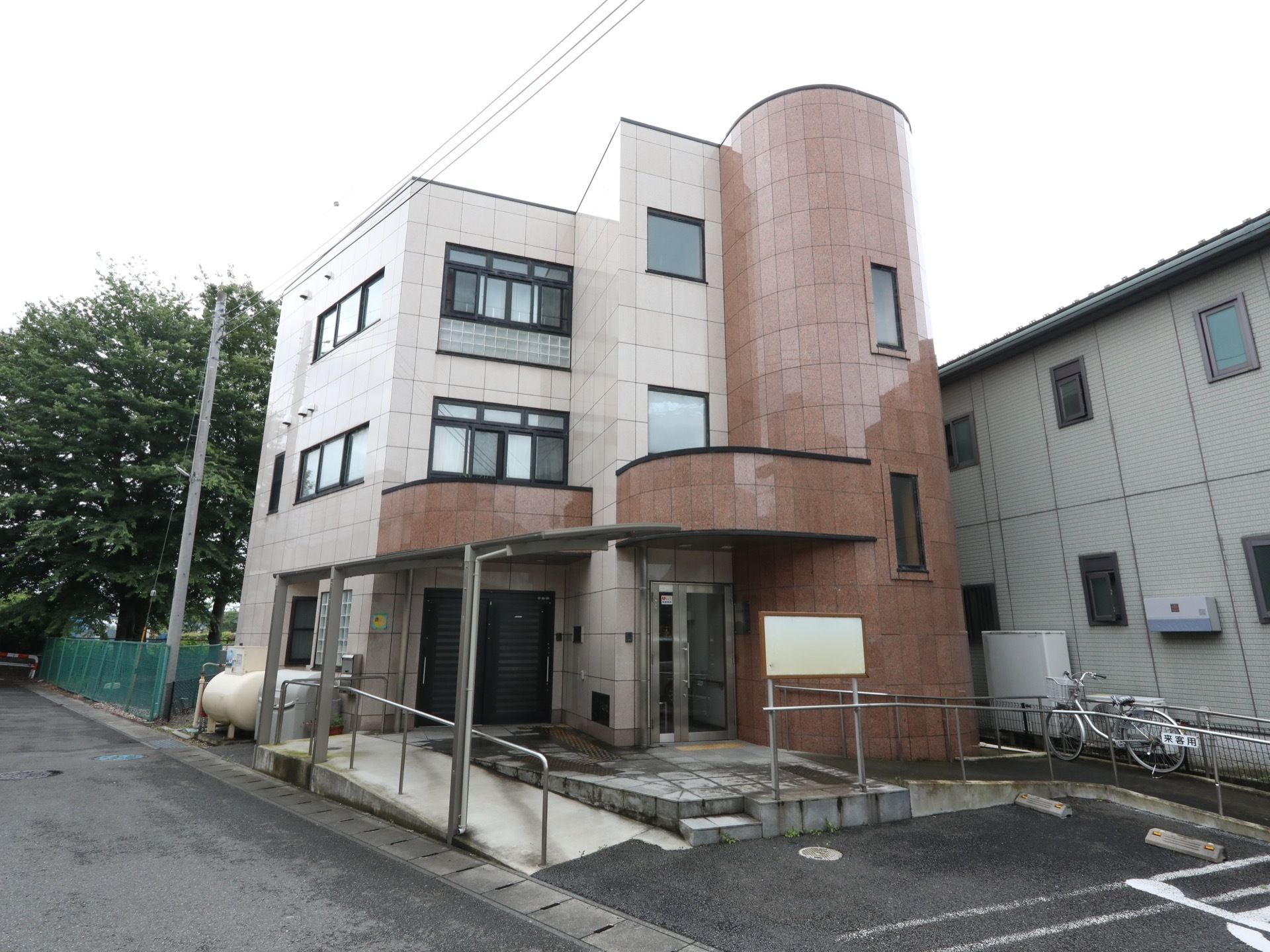 丸みを帯びた部分のある３階建ての施設である。敷地面から一段高い所に玄関があり、手すりがついたゆるやかなスロープが造られている。