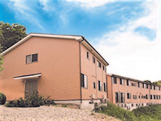 2階建ての建物。周辺には自然が多く、のどかな雰囲気。ブラウンを基調としている。