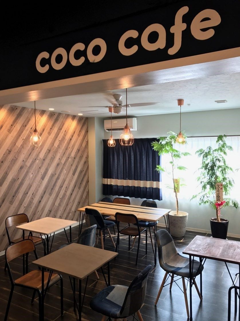カフェのような雰囲気のおしゃれな館内。テーブルセットが複数並び、窓際には観葉植物もある。
