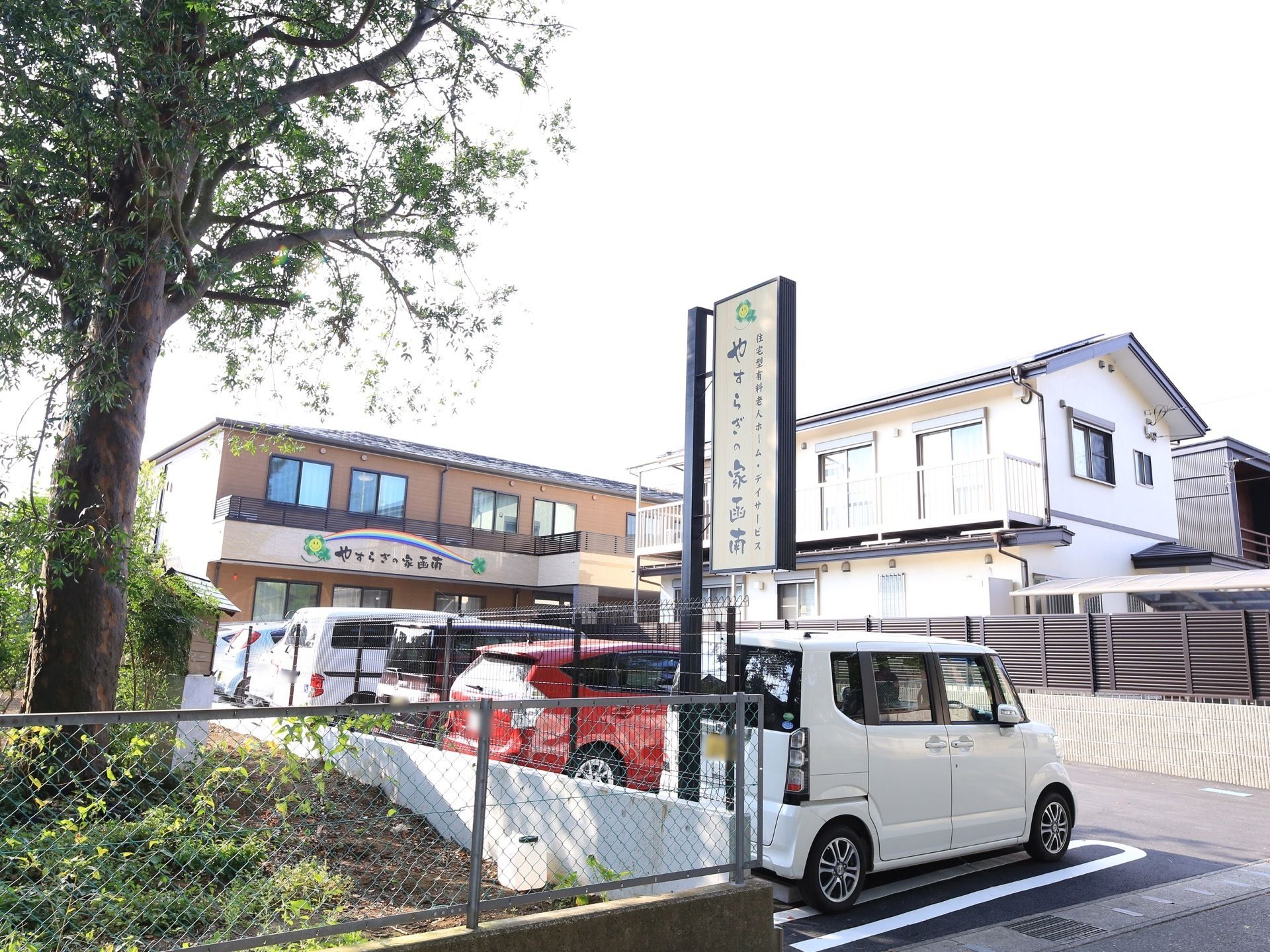 茶色を基調とした外壁を持つ２階建ての施設である。建物と道路との間に駐車スペースがあり、車が何台も停まっている。