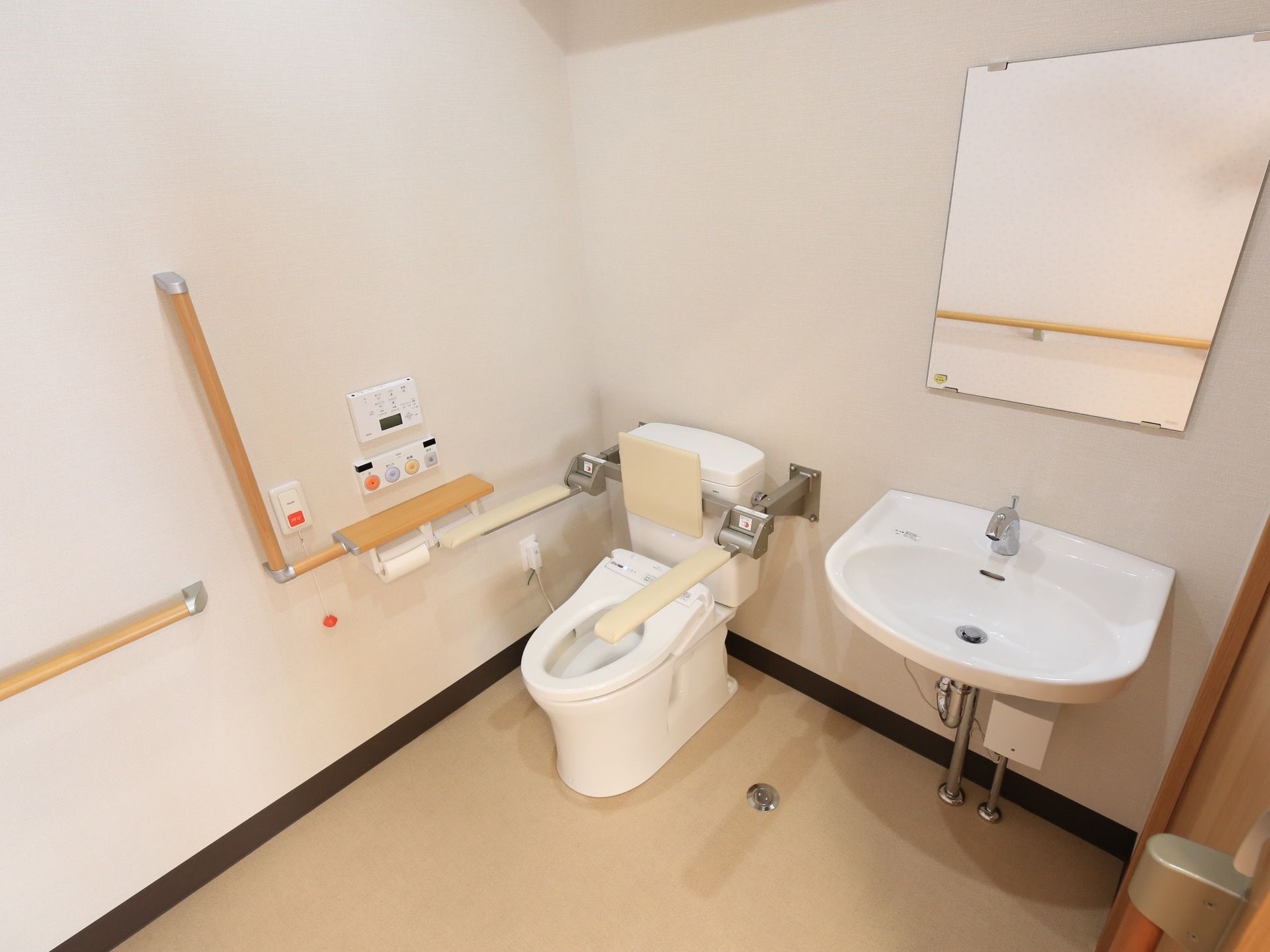 引き戸を開けた所にトイレが設置されている。便器の右側に自動水栓の洗面台があり、前の壁に鏡が取り付けられている。