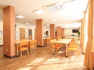オレンジ色があちらこちらに使われていてとても明るい印象の食堂である。壁にテレビが取り付けられている。