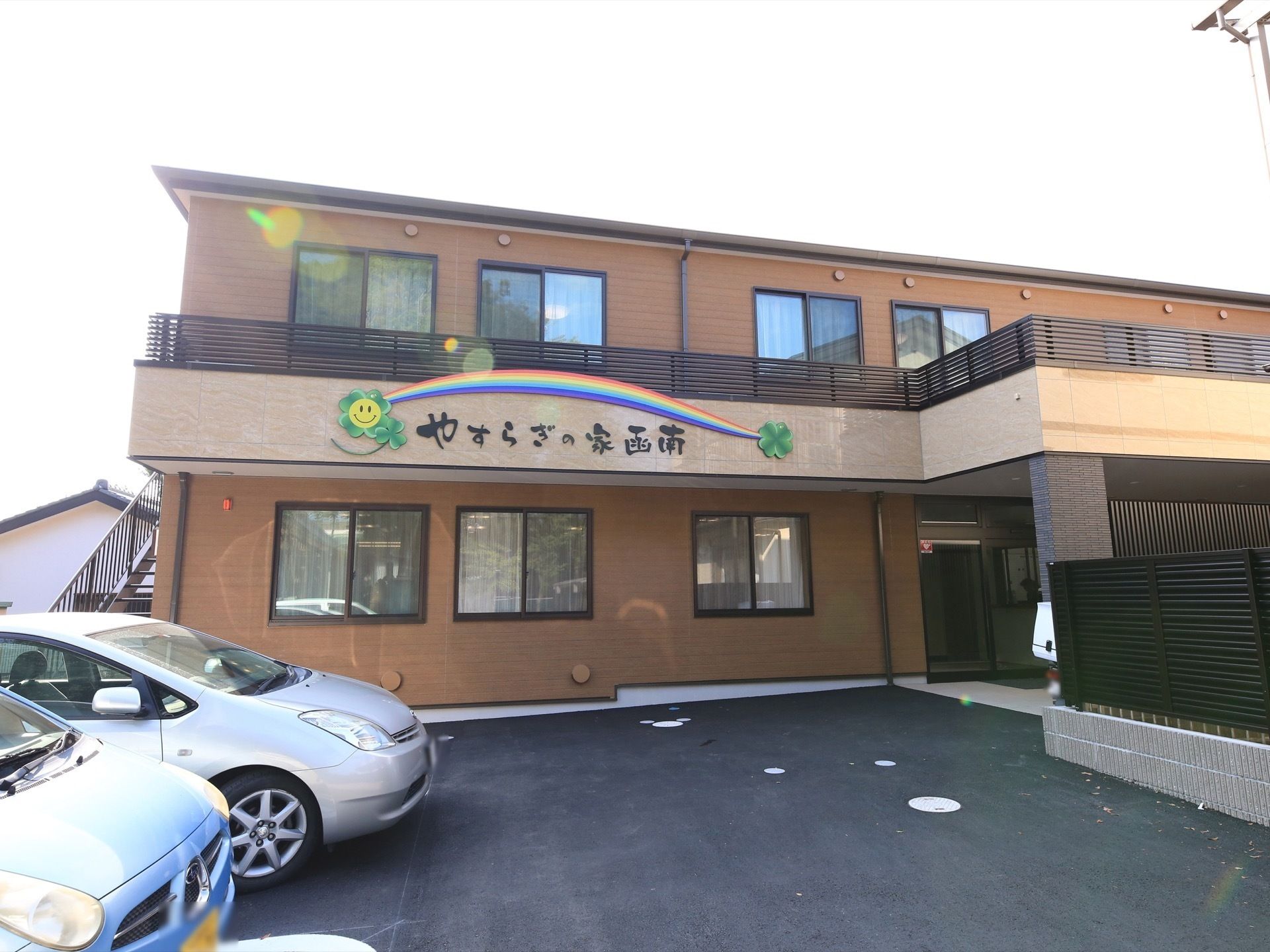 入り口には大きな庇があり、駐車スペースも確保された２階建ての建物