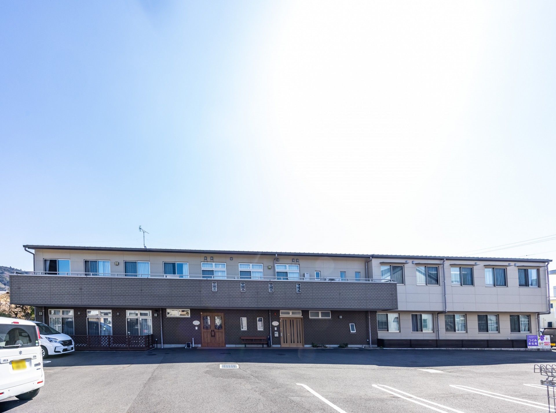 鏡を見ながら笑顔で話している高齢者とそこに寄り添介護スタッフの様子。明るい室内の写真