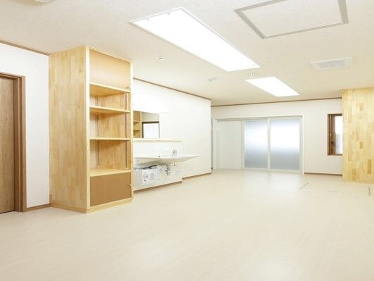 木製の大きな棚が付いた脱衣所は広く、車いす対応の洗面所があり、大きなドアが浴室についている。