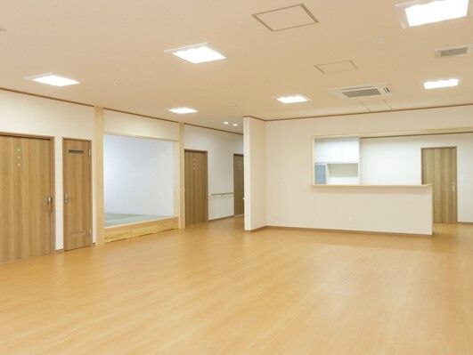 左側には畳スペースがあり、正面には対面式キッチンがあり、家具や家電はなく、フローリングのフロア。
