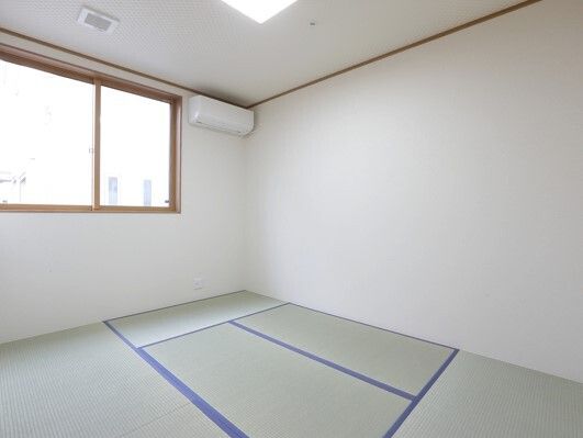 畳敷きの和室にはカーテンの付いていない窓があり、エアコンも設置されている。家具も置かれていない。