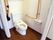 フラットなフロアに設置されたトイレスペース。2方向の壁には手すりがあり、座り立ち動作をサポートする。ナースコールがある。
