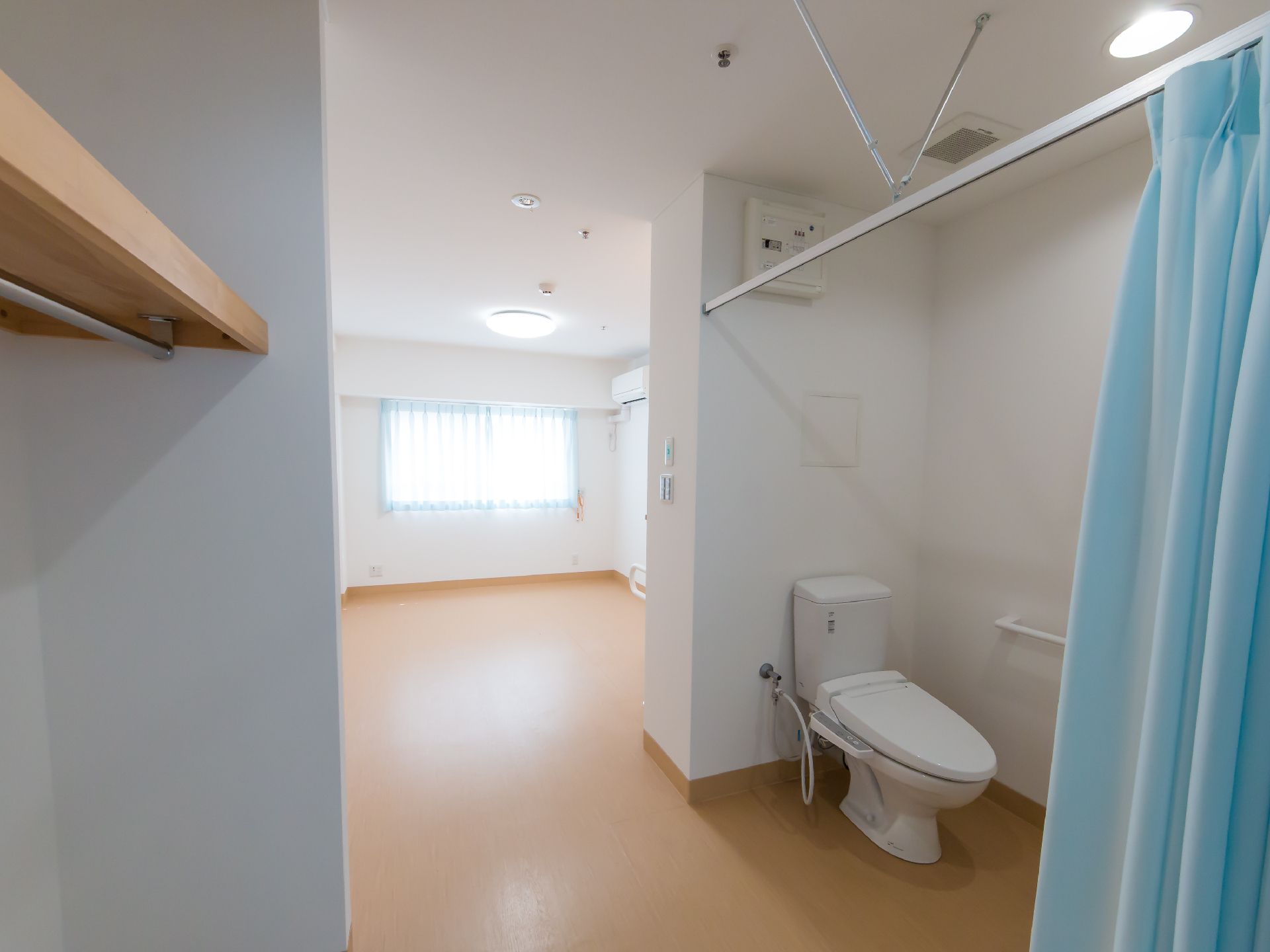トイレ部分はドアではなく水色のカーテンで仕切るようになっている広い居室