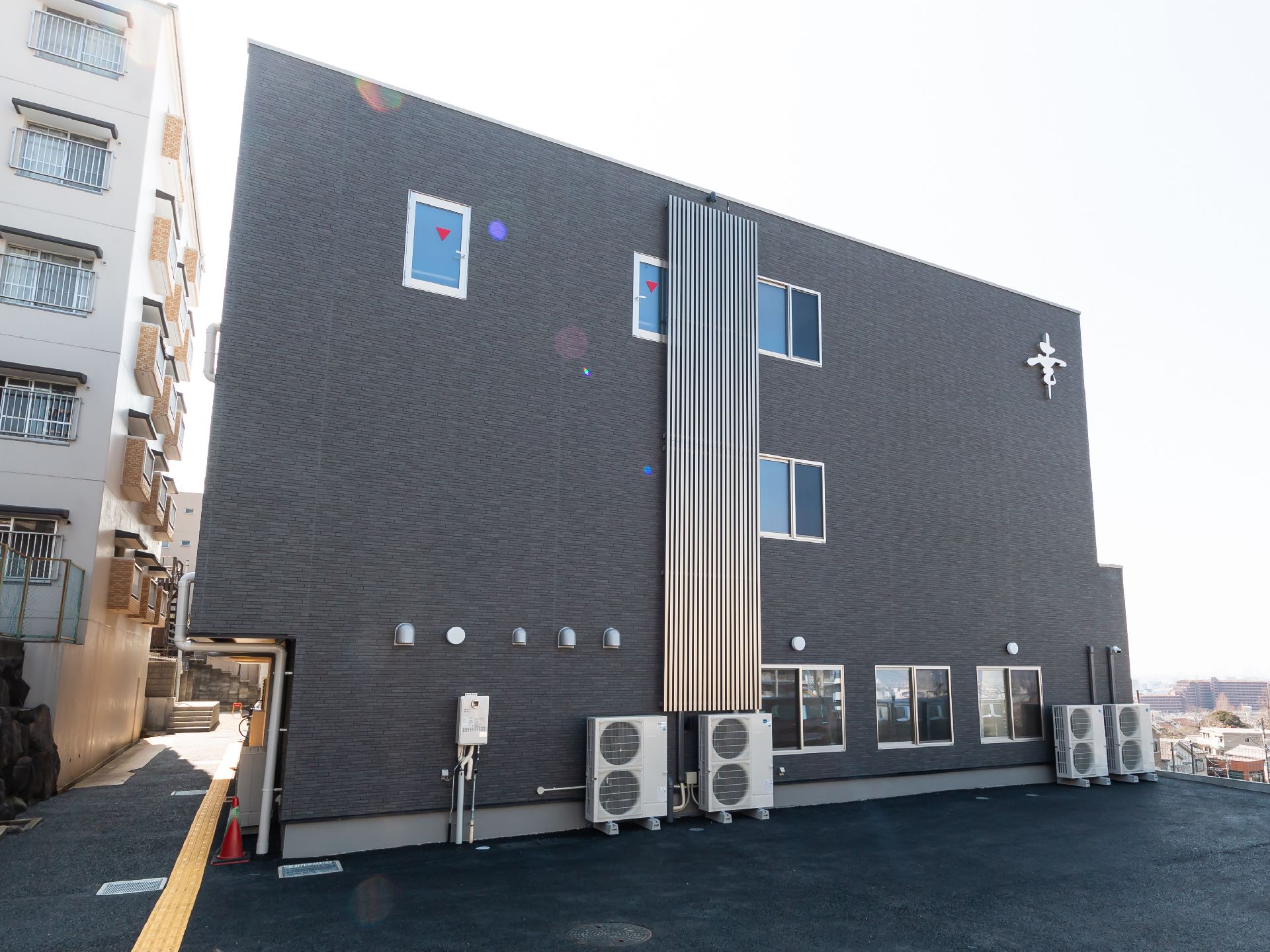 各フロアにベランダが付いた3階建ての建物の屋上にはソーラーパネルが設置されている。