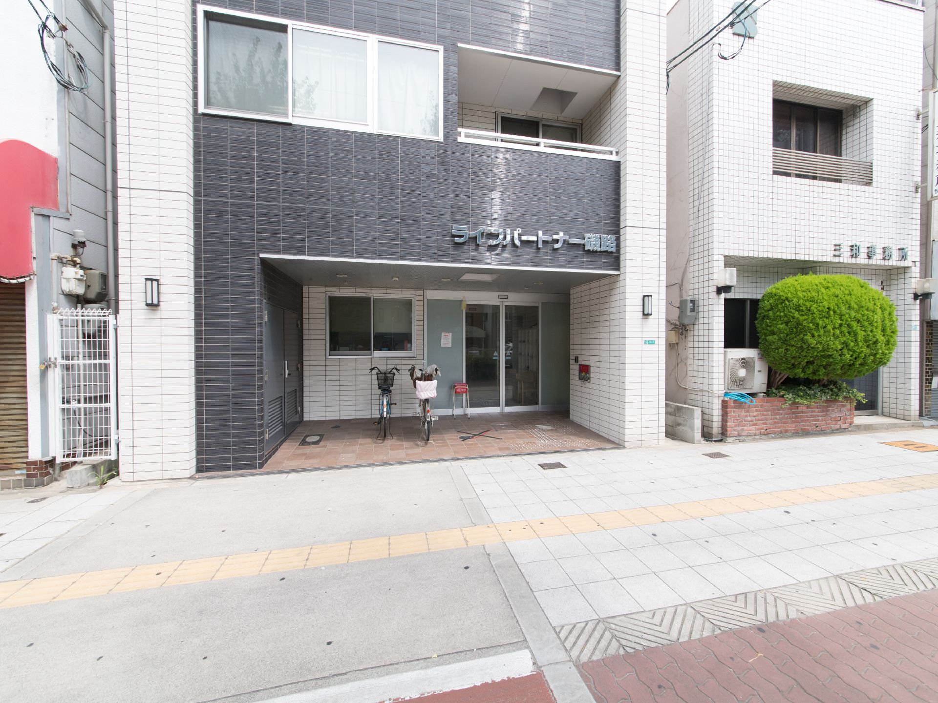 施設前の道路には視覚障害者誘導用のブロックを設置している。また道路と施設は、段差のない地面でつながっている。