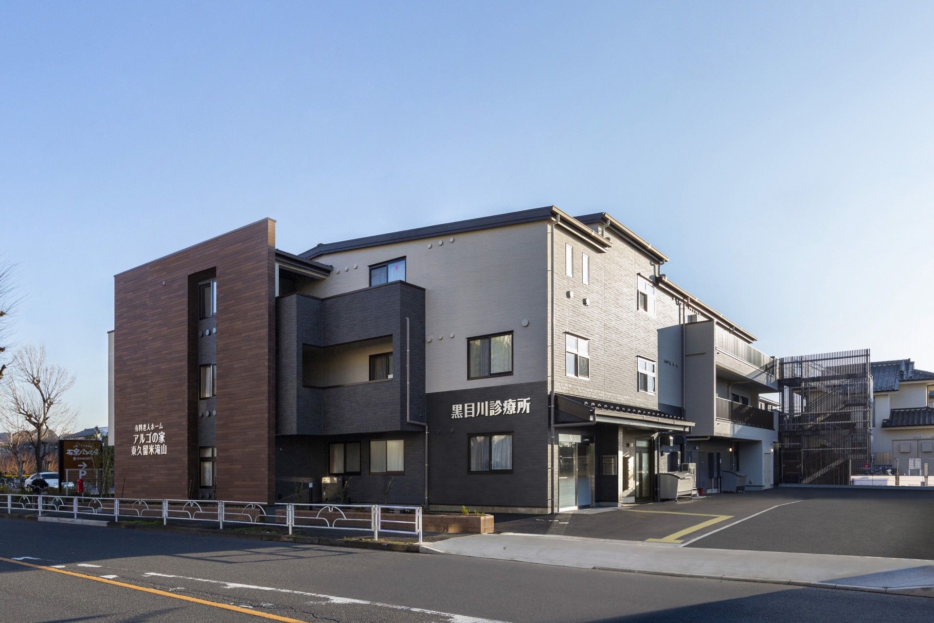 施設に併設された３階建ての医療機関である。入口に設置された自動扉の上部には、ひさしが設けられている。