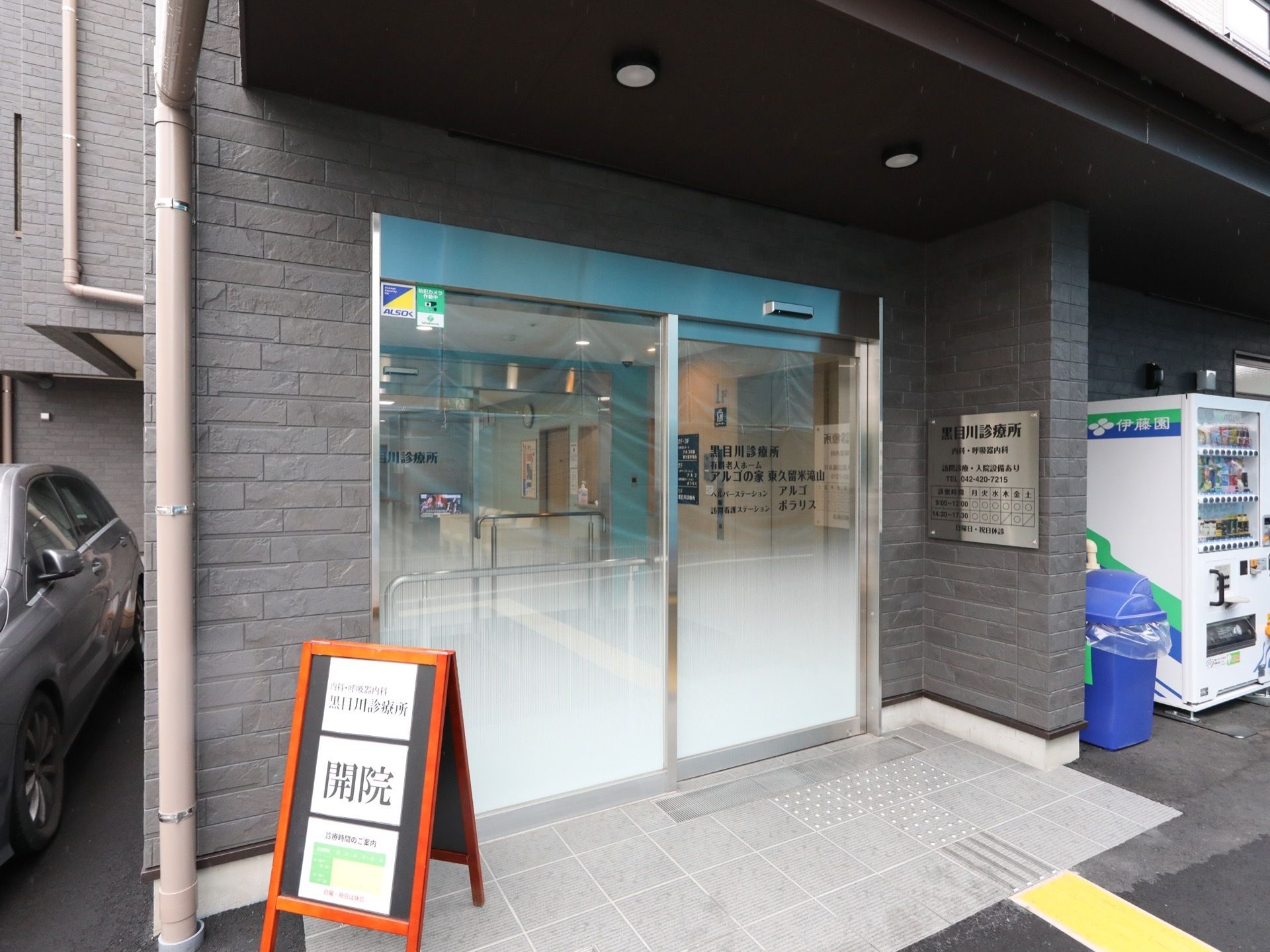施設と併設している医療機関の入口である。間口広く自動扉が設置され、点字ブロックが備え付けられている。