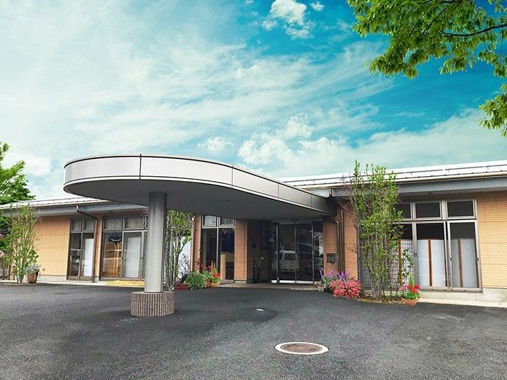 平屋建ての住宅型有料老人ホームの外観。雨除けのひさしが付いた車止めがある