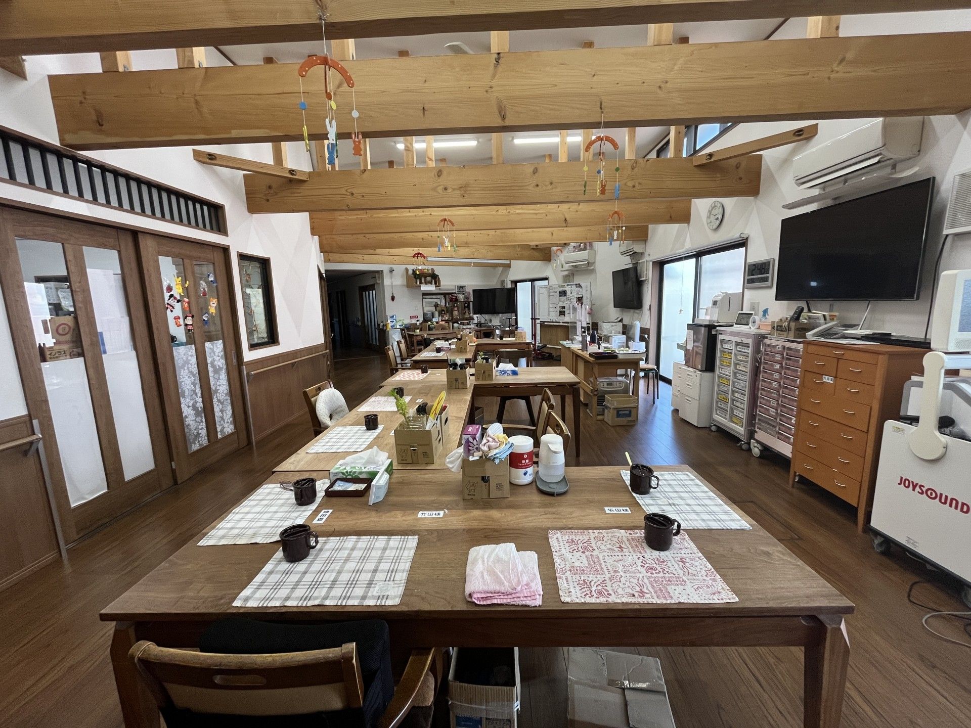 からだを動かしている高齢女性と男性スタッフの様子。施設内で体操しているときの一場面