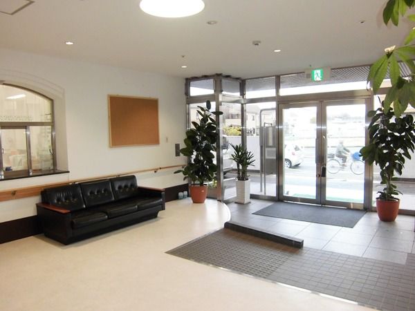 大きなソファや観葉植物が置いてあるエントランス部分。左側にスタッフステーションがある