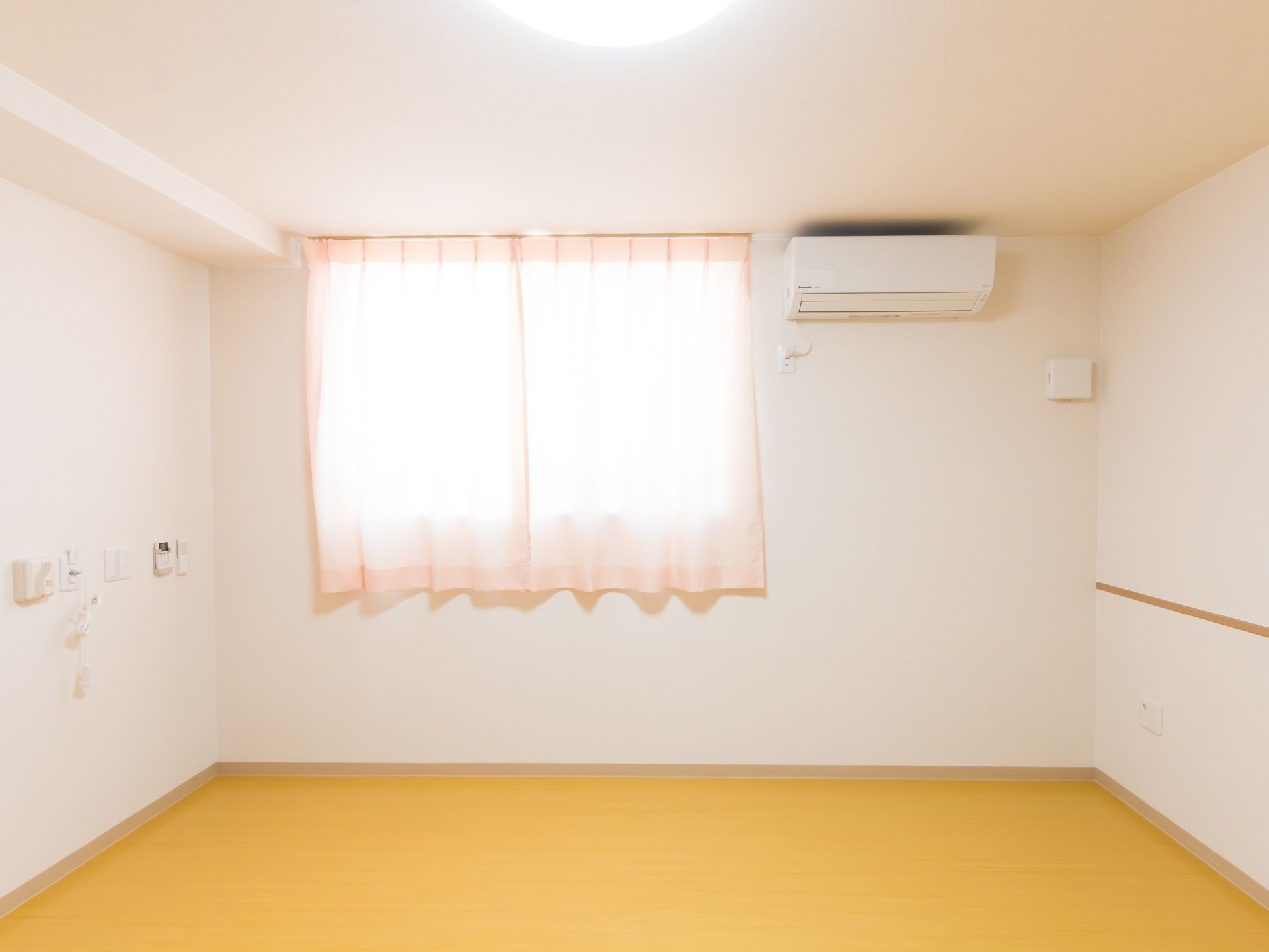 居室にはエアコンが完備されているので寒暖差を気にせず過ごせる。１ヵ所にエアコンなどの操作パネルや緊急ブザーがかかっている。