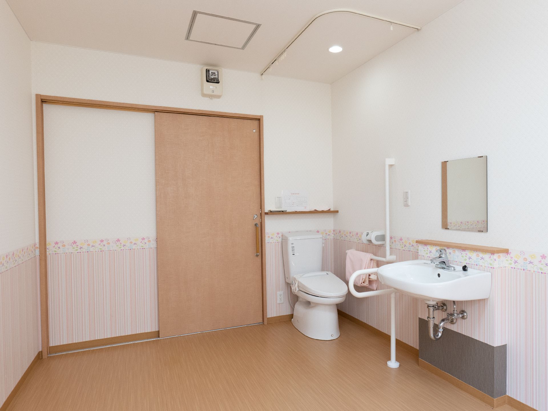 大きなミラー付きの洗面台を備えたトイレ