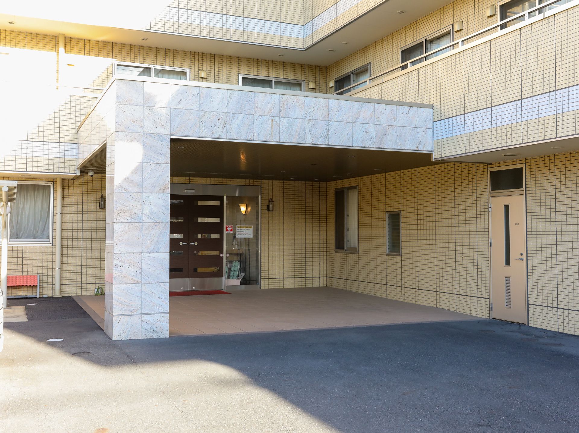 看板が設置され、段差が極力排除された介護施設の外観