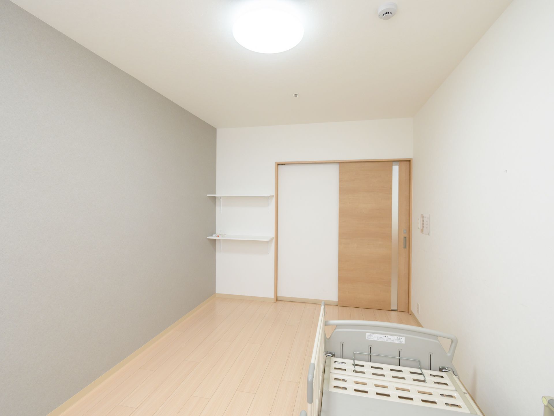 窓から日差しが入り、介護ベッドが置かれている居室