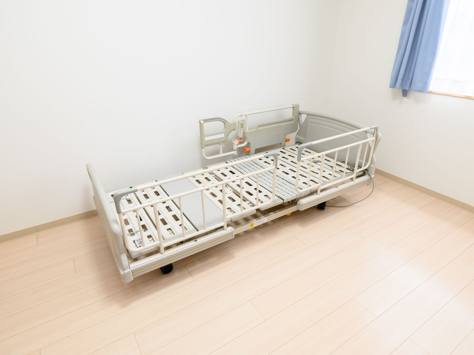 窓から日差しが入り、介護ベッドが置かれている居室