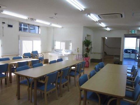 白を基調とした広い食堂。長方形のテーブルに椅子が8脚囲むように置かれている。窓も多く自然光も入り明るい雰囲気だ。