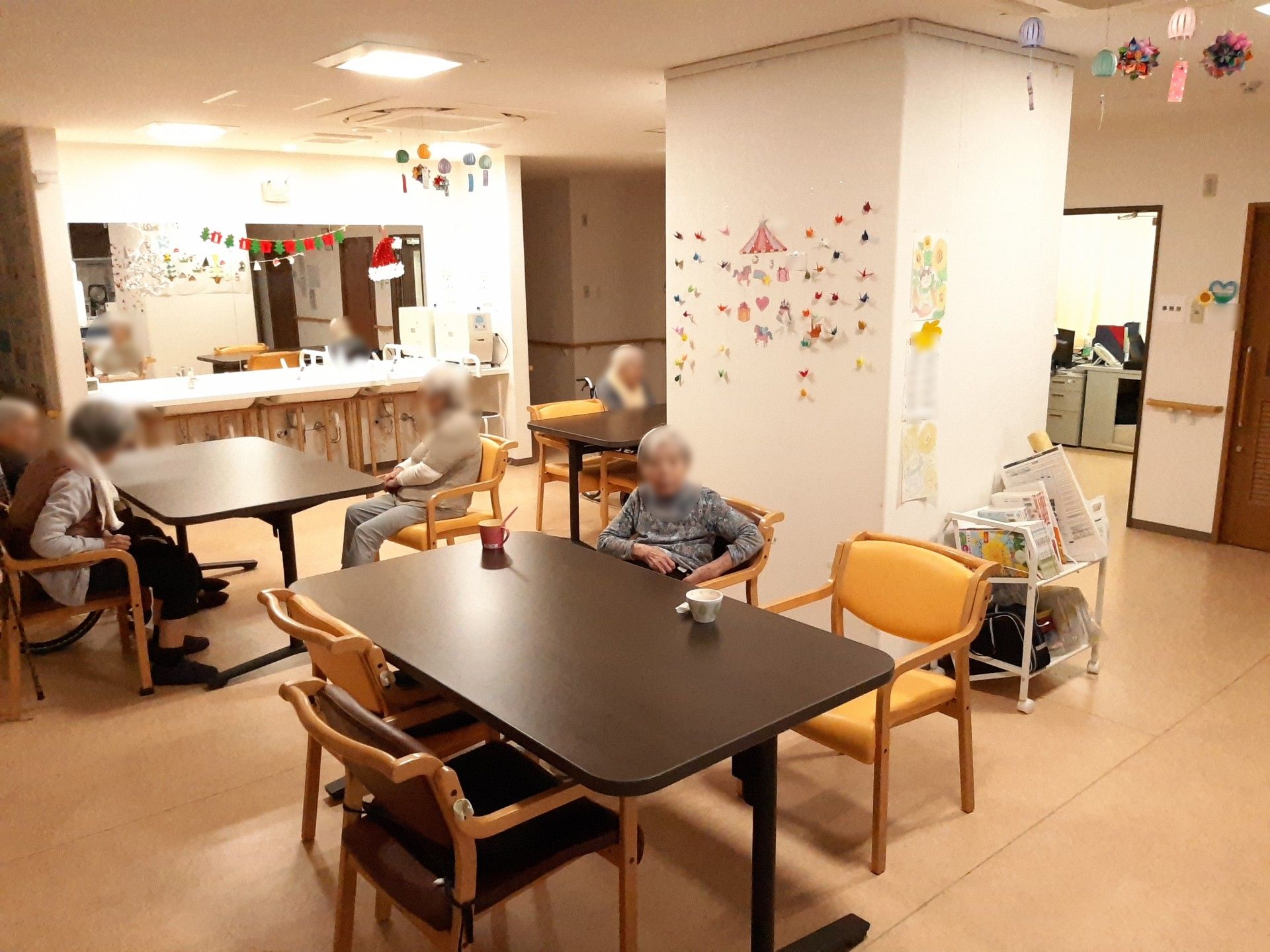 晴れた天気のもと、ご高齢な男女4名が景色を見ながら微笑んでいる様子