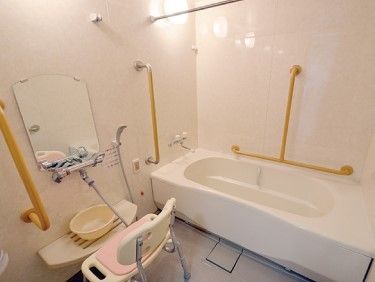 手すりやシャワーチェアが置かれた浴室。呼び出しボタンもついている。
