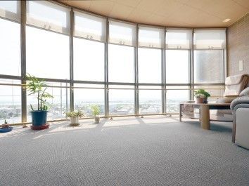 観葉植物が窓際にずらりと並べられたラウンジ。周辺風景を見渡せる位置に椅子が置かれている。