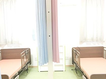 ベッドが二つ置いてありその間についた手がある相部屋の様子