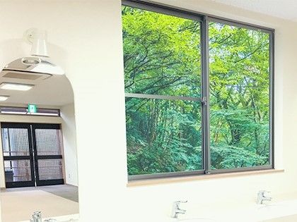 窓の向こう側に豊かな自然が広がっている施設内の共有スペースの様子