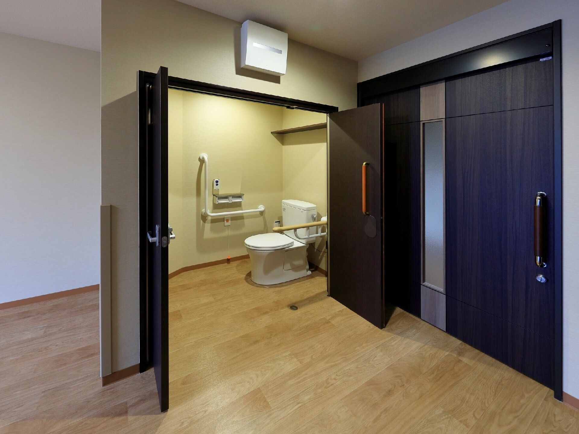 大きく扉を開けることができる広いトイレ内には手すりが複数付き、操作ボタンや呼び出しボタンが付いている。